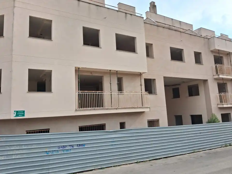 Fachada a la calle, con el vallado de obra